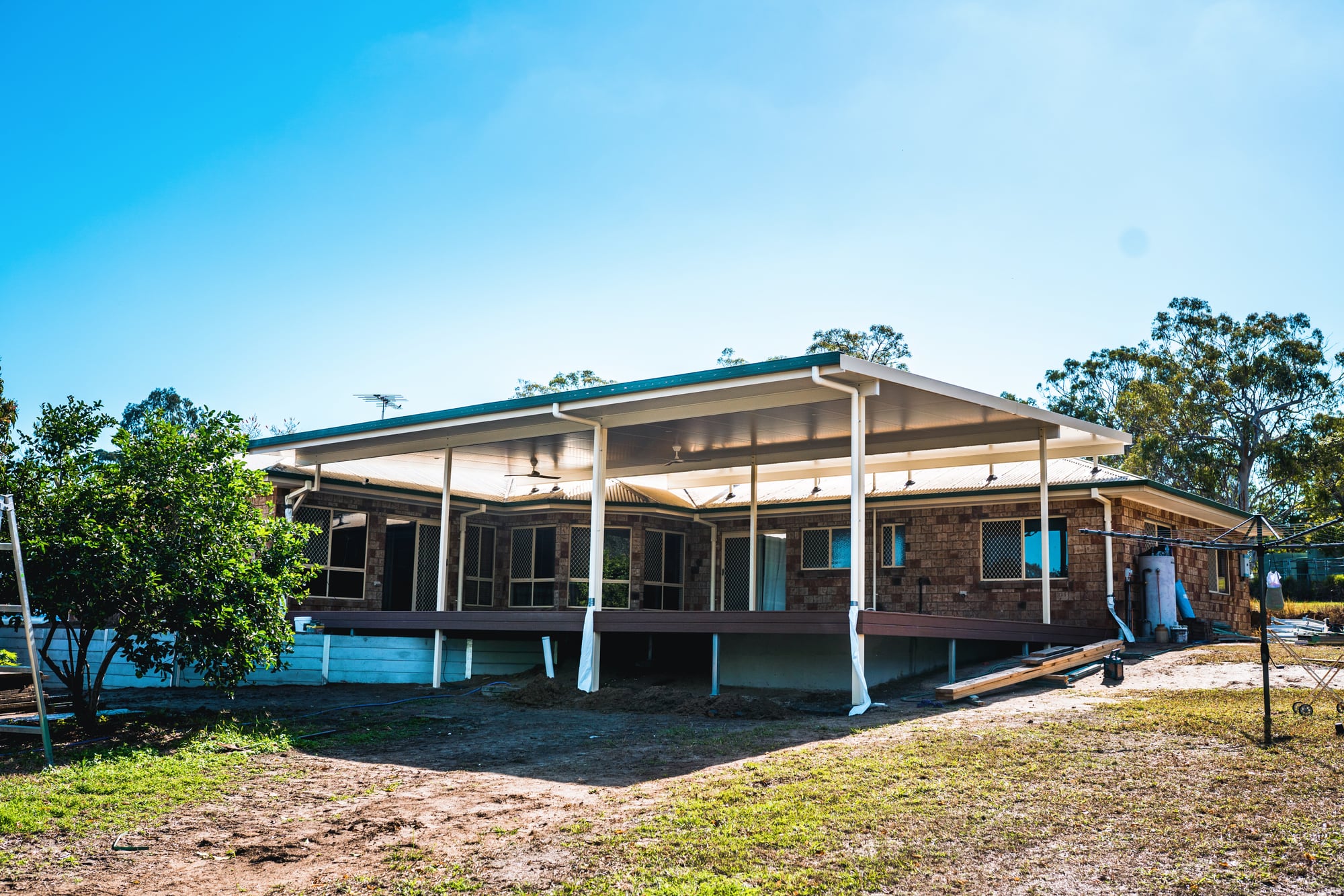 Finished patio attached to a Brisbane brick home under a clear blue sky