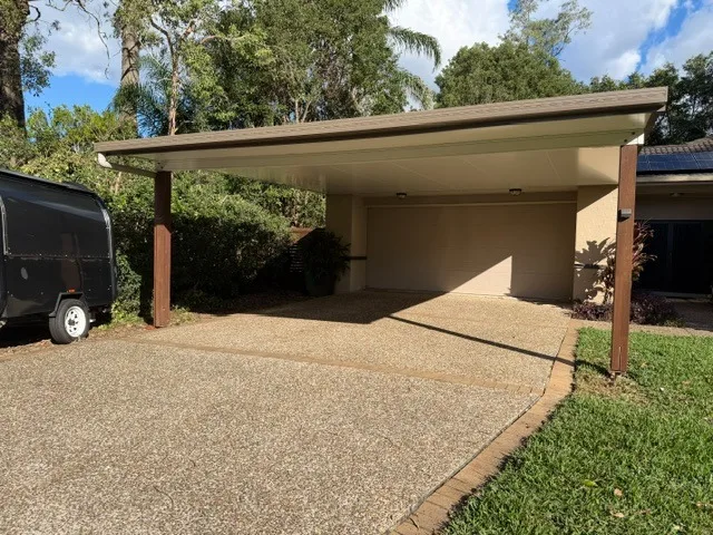 Freestanding flyover cover sheltering a trailer beside a Queensland home